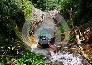 Rappelling on forest waterfall