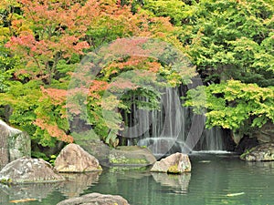 Waterfall and red leaves in autumn season at Koko-en garden, Himeji, Japan.