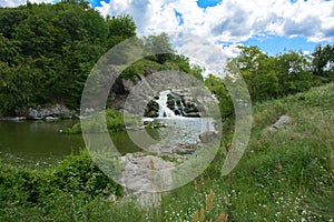 The waterfall on the river flows through and over the rocks cove