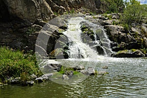 The waterfall on the river flows through and over the rocks cove