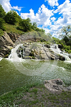 The waterfall on the river flows through and over the rocks cove