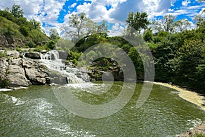 The waterfall on the river flows through and over the rocks cove