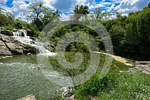 The waterfall on the river flows through and over the rocks cove