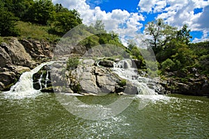 The waterfall on the river flows through and over the rocks cove