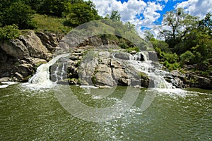 The waterfall on the river flows through and over the rocks cove