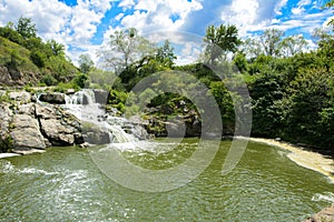 The waterfall on the river flows through and over the rocks cove