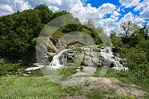 The waterfall on the river flows through and over the rocks cove