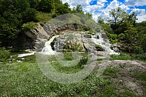 The waterfall on the river flows through and over the rocks cove