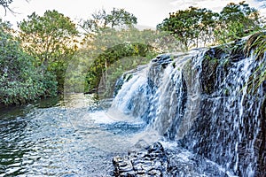 Waterfall and river with water running over the rocks and betweem the tropical forest