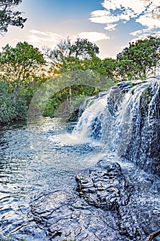 Waterfall and river with water running over the rocks and betweem the tropical forest