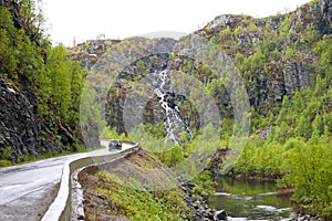 Waterfall and road in mountains in Finnmark, northern Norway