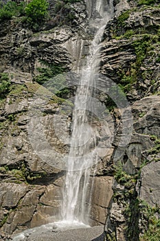 Waterfall among rocks and forests on the Alps