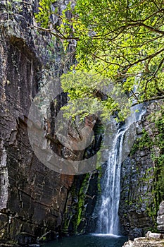 Waterfall between rocks with moss and preserved vegetation photo