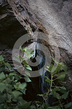 A waterfall, with rocky outcroppings and lush green trees surrounding the area, Angeles forest