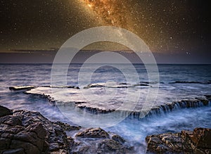 Waterfall in sea and milky way