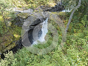 Waterfall Slettafossen at Verma with viewpoint platform deep narrow Rauma river canyon at Romsdalen valley with rocks photo