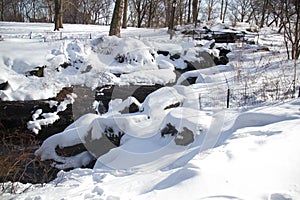 Waterfall between snow and fence in the park