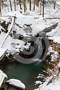 Waterfall in the snowy winter forest in polish moutnains photo