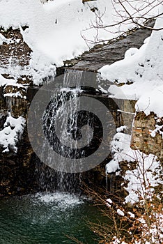 Waterfall in the snowy winter forest in polish moutnains photo