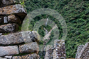 Waterfall from stone ruins Inca town.