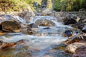 Waterfall with stones in wild nature in Fragas de Sao Simao, Figueiro dos Vinhos, Leiria, Portugal photo