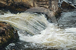Waterfall stream with foam under the bridge in Belmontas park in Vilnius