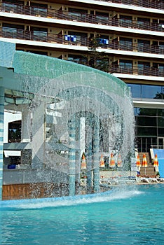 Waterfall and swimming pool in front of a hotel