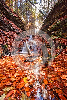 Waterfall in Tajovska dolina gorge near Tajov village during autumn sunset