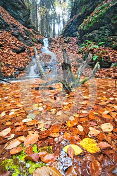 Waterfall in Tajovska dolina gorge near Tajov village during autumn sunset