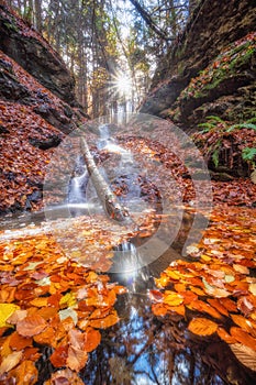 Waterfall in Tajovska dolina gorge near Tajov village during autumn sunset