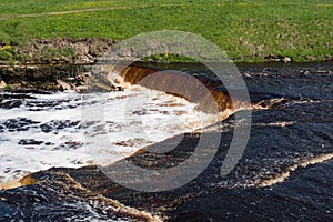 Waterfall on the Tosno River with rapids and stony shore.  Sablino. Leningrad region. Russia