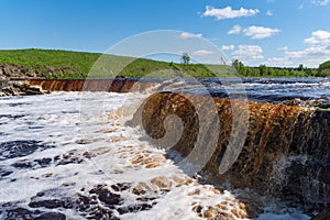 Waterfall on the Tosno River with rapids and stony shore.  Sablino. Leningrad region. Russia