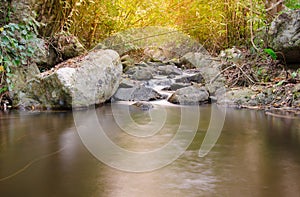 Waterfall in the tropical forest with sunlight.