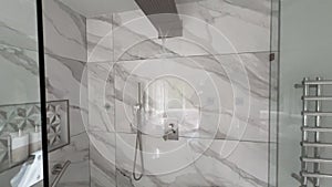 Waterfall type shower faucet running in large master bathroom shower