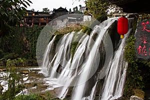 Waterfall under the ancient architecture at Furong Town of China