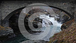 Waterfall under bridge in Bovra river in Lom in Norway in autumn