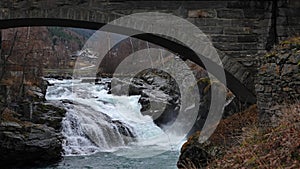 Waterfall under bridge in Bovra river in Lom in Norway in autumn