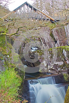 Waterfall Under Footpath Walking Bridge Running through the Woods