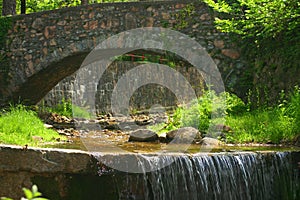 Waterfall under a stone bridge