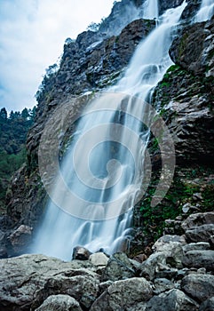 Waterfall white water stream falling from mountains at day from flat angle