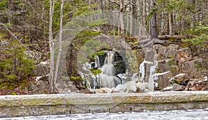 Waterfall in winter forest.l Hiking Trail. Rocks Ice and Moss