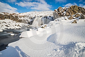 Waterfall in winter in Iceland in mountains