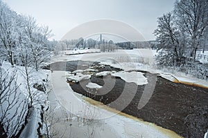 Waterfall in winter, strong current, frozen ice and trees in other. landscape photography Frost, ice, cold concept. Old