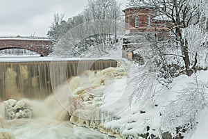 Waterfall in winter, strong current, frozen ice and trees in other. landscape photography Frost, ice, cold concept. Old