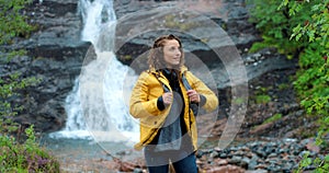 Waterfall, woman and hiking of a person on an exercise adventure and travel outdoor. Happy female relax in natural