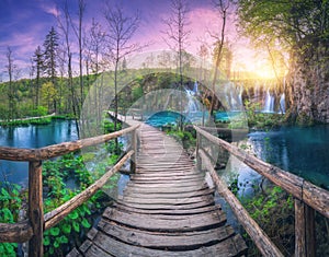 Waterfall and wooden path in green forest. Plitvice Lakes Croatia
