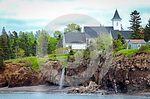 Waterfalls behind a church. Edge of Canada at Margaretsville, Bay of Fundy. Low tide in Nova Scotia.