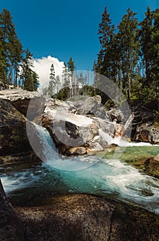 Waterfalls of cold creek in High Tatras National park. Mountain river  with crystal clear water in beautiful sunny day