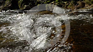 Waterfalls on mountain river slow motion view, clearness and freshness of nature. Winter sunny day.