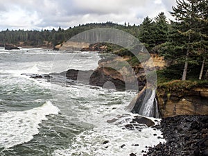 Waterfalls into surf on rugged coast